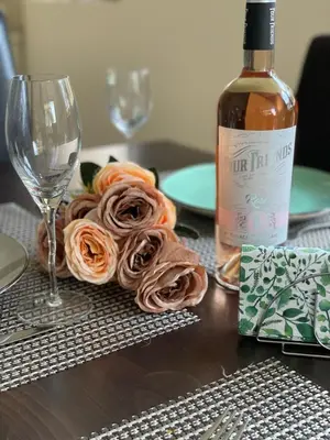 a table with a bottle of wine and a plate of roses at Villa Rada, Bay View Villas in Kosharitsa