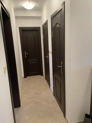 a hallway with three brown doors and a tile floor at Villa Rada, Bay View Villas in Kosharitsa