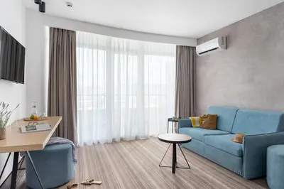 a living room with a blue couch and a table at PERLA TUI SUNEO All inclusive in Sunny Beach
