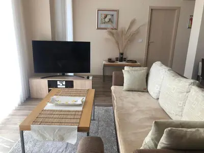 a living room with a couch and a tv at Obzor Beach Resort Beachfront in Obzor