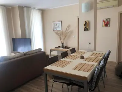 a living room with a table and a couch at Obzor Beach Resort Beachfront in Obzor