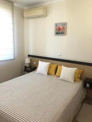a bedroom with a bed with white and yellow pillows at Obzor Beach Resort Beachfront in Obzor