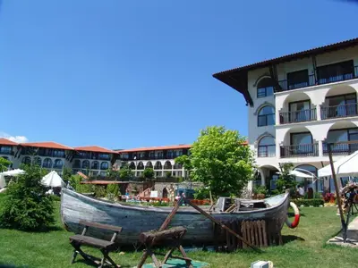 a boat sitting on the grass in front of a building at Monastery Apartment 14, St. Vlas in Sveti Vlas