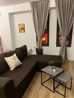 a living room with a black couch and a table at Studio Marrone on Bogoridi in Burgas City
