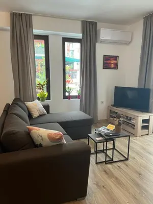 a living room with a couch and a flat screen tv at Studio Marrone on Bogoridi in Burgas City