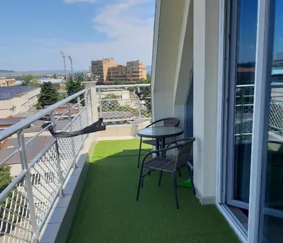 a balcony with a table and chairs on a building at Studio Milenium in Pomorie