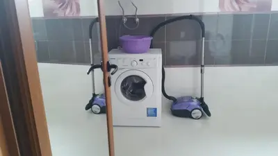 a washing machine in a bathroom with two vacuum cleaners at Studio Milenium in Pomorie