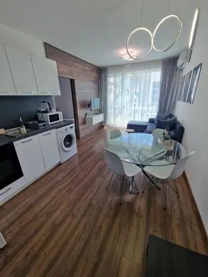 a kitchen and a living room with a glass table at Апартамент СаMи in Burgas City