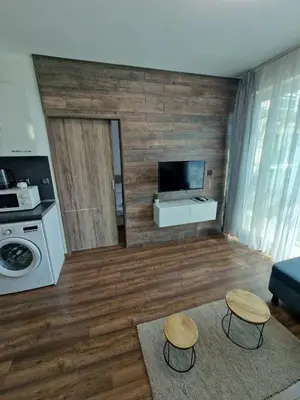 a living room with a television and two stools at Апартамент СаMи in Burgas City