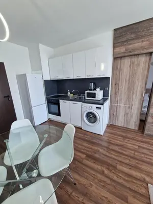 a kitchen with white cabinets and a washer and dryer at Апартамент СаMи in Burgas City
