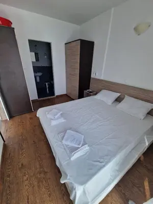 a bedroom with a large white bed with two pillows at Апартамент СаMи in Burgas City