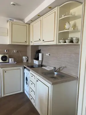 a kitchen with white cabinets and a sink at Penthouse Happy Moments 2 in Sunny Beach