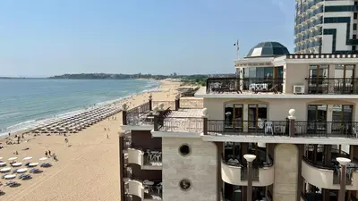 a building next to a beach with umbrellas at Penthouse Happy Moments 2 in Sunny Beach