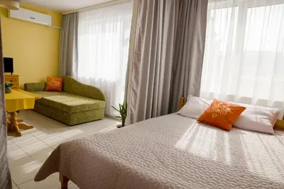 a bedroom with a bed and a couch and a window at Panorama Chantall-izby,apartmány s výhľadom na more in Ravda