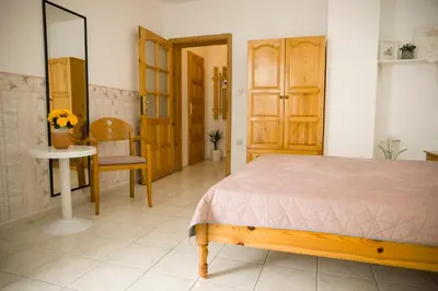 a bedroom with a bed and a table and a chair at Panorama Chantall-izby,apartmány s výhľadom na more in Ravda
