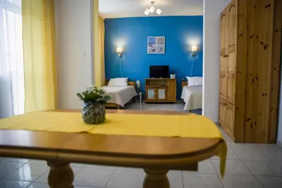 a living room with two beds and a table in a room at Panorama Chantall-izby,apartmány s výhľadom na more in Ravda