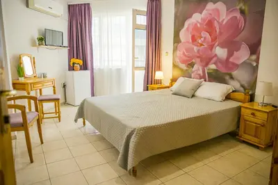 a bedroom with a bed with a flower painting on the wall at Panorama Chantall-izby,apartmány s výhľadom na more in Ravda