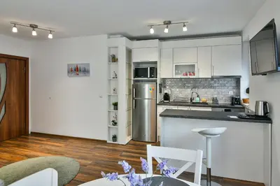 a kitchen with white cabinets and a table and chairs at Varna beach flat 1 in Varna City