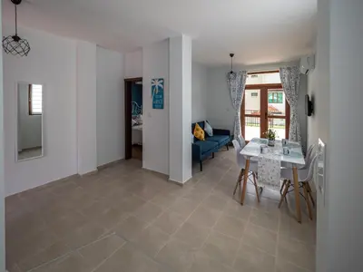 a living room with a table and a blue couch at Buongiorno! Premium in Sveti Vlas