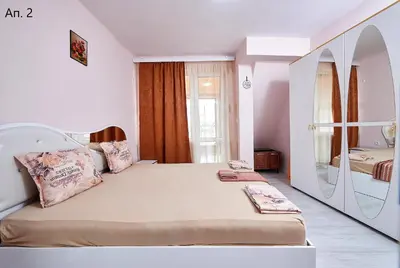a bedroom with a large bed with a mirror at Апартаменти Боряна in Pomorie