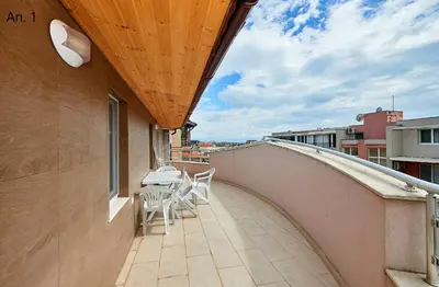 a balcony with chairs and a table on a building at Апартаменти Боряна in Pomorie