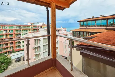 a balcony with a view of buildings and the ocean at Апартаменти Боряна in Pomorie