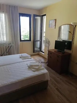 a bedroom with two beds and a mirror and a television at Созопол Дриймс FSM Апартамент in Sozopol