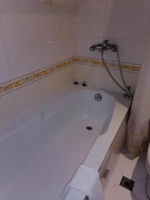 a white bath tub with a shower in a bathroom at Созопол Дриймс FSM Апартамент in Sozopol