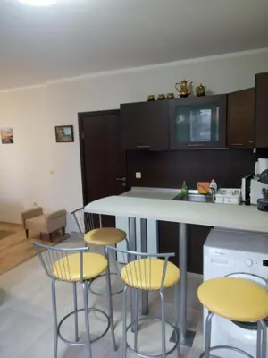 a kitchen with four chairs and a white counter at Созопол Дриймс FSM Апартамент in Sozopol