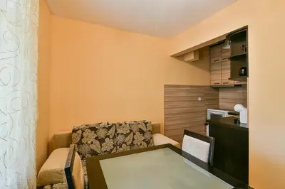 a small living room with a table and a chair at Budget central next to sea garden and beach in Varna City