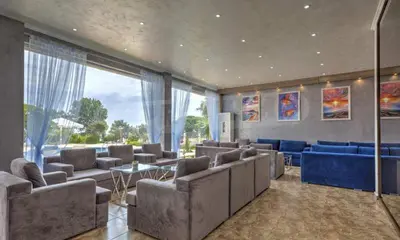 a large living room with couches and blue furniture at Студио Симона 4 - първа линия море in Lozenets