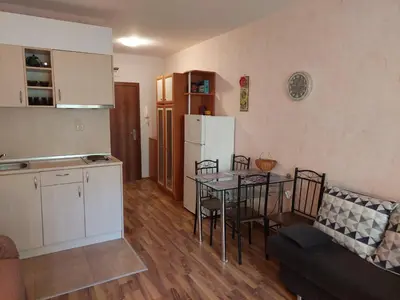a kitchen and a dining room with a table and a refrigerator at Святой Влас, комплекс Sea Breeze in Sveti Vlas