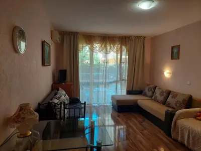 a living room with a couch and a glass table at Святой Влас, комплекс Sea Breeze in Sveti Vlas