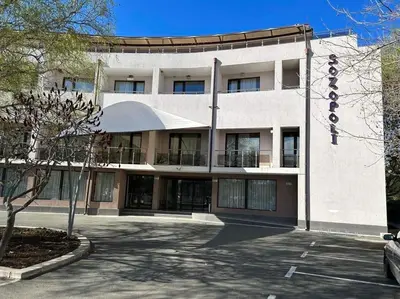 a large white building with a sign on it at Студио Нели- Созополистайл Клуб in Sozopol