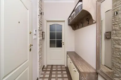a hallway with a white door and a wooden bench at Cozy central flat in Varna Downtown in Varna City