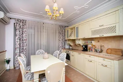 a kitchen with white cabinets and a table and chairs at Cozy central flat in Varna Downtown in Varna City