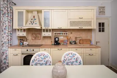 a kitchen with white cabinets and a table and chairs at Cozy central flat in Varna Downtown in Varna City