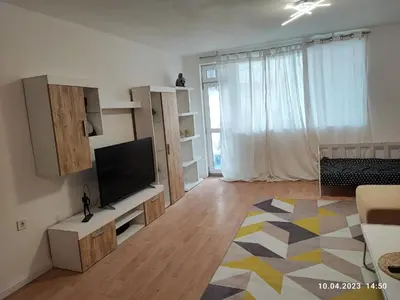 a living room with a flat screen tv and a large window at Royal Apartments Varna in Varna City