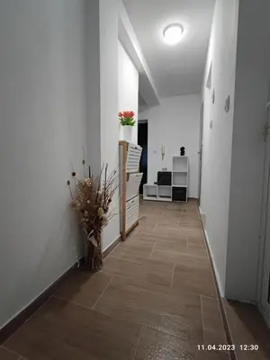 a hallway with a room with white walls and a tile floor at Royal Apartments Varna in Varna City