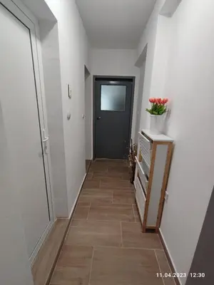 a hallway with a black door and a wooden floor at Royal Apartments Varna in Varna City