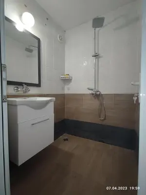 a bathroom with a sink and a shower with a mirror at Royal Apartments Varna in Varna City