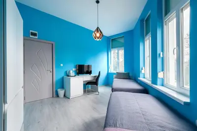 a room with blue walls and a desk and a door at ПАЦО in Burgas City