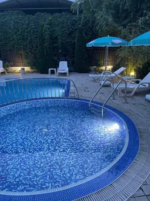 a large blue swimming pool with an umbrella and chairs at VIOLET GARDEN 2 Veranda Apartment in Sunny Beach