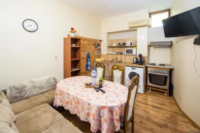 a living room with a table and a kitchen at Summer Square - 2 bedrooms Retro Flat with great location, 1st fl in Burgas City