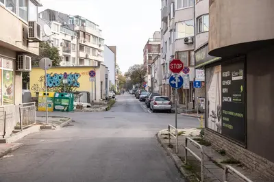 an empty city street with a stop sign and cars at Central 3BR with parking nearby Opera in Varna City
