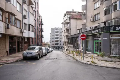 an empty street with cars parked on the sides of buildings at Central 3BR with parking nearby Opera in Varna City