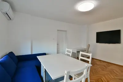 a living room with a blue couch and a white table at Central 3BR with parking nearby Opera in Varna City