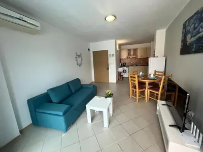 a living room with a blue couch and a table at Large apartment in Sunny Beach in Sunny Beach