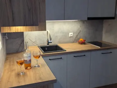 a kitchen with two glasses of wine on a counter at Sunny place in Sveti Vlas