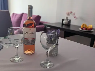 a bottle of wine and two wine glasses on a table at Sunny place in Sveti Vlas